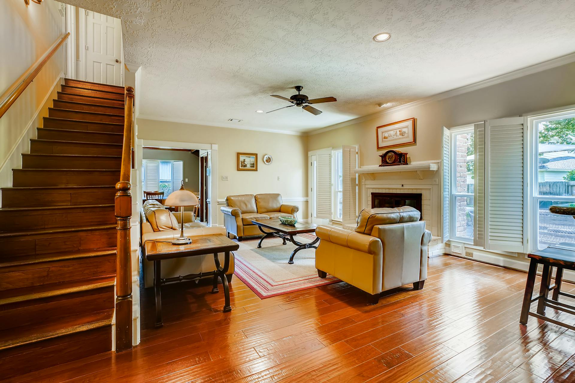 Living room with gleaming hardwood floors and wooden staircase