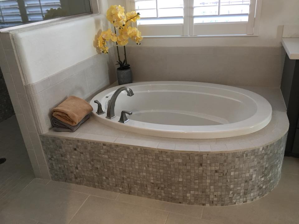 Completed oval tub installation with brushed nickel fixtures