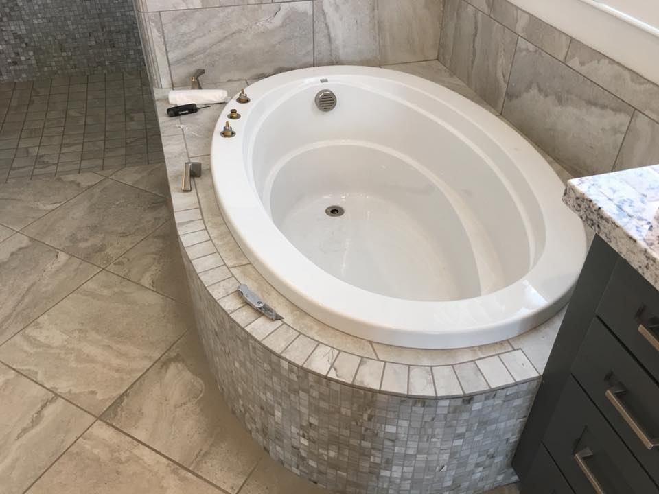 Marble bathtub surround with mosaic tile detail