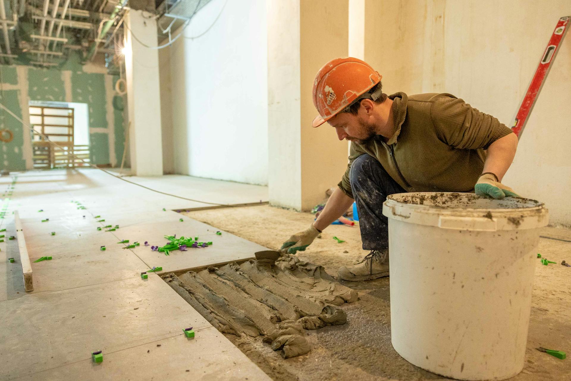 Installer laying tile flooring during a home renovation
