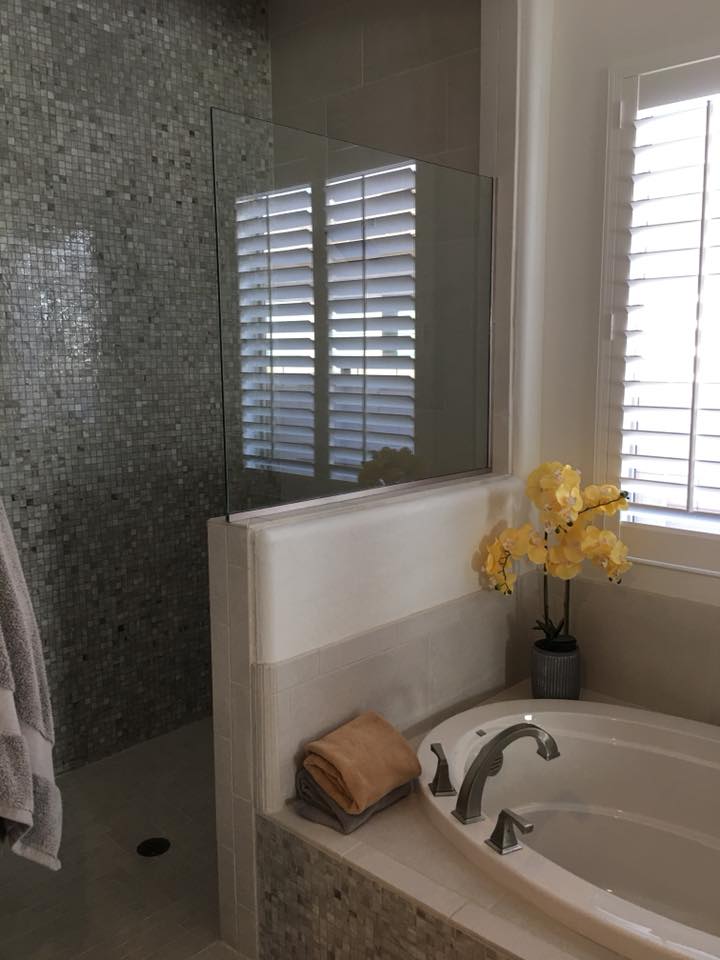 Frameless glass shower partition with mosaic tile wall